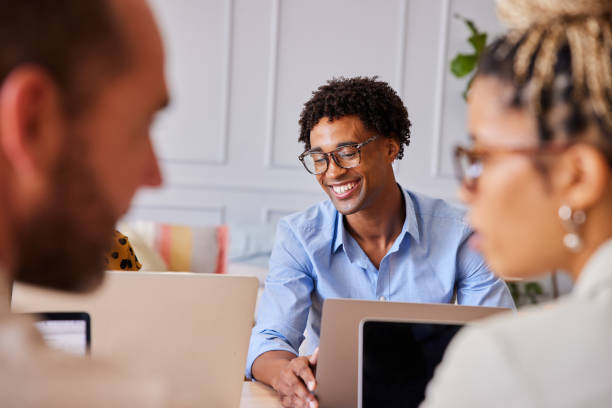 istock Young businessman laughing while working with colleagues in an office 1340444917