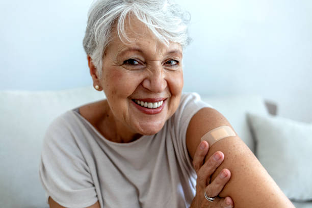 signora anziana che ottiene l'immunizzazione tramite vaccino antivirale. - injecting foto e immagini stock