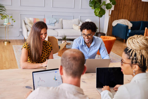 istock Diverse group of young businesspeople working on laptops together 1340445775