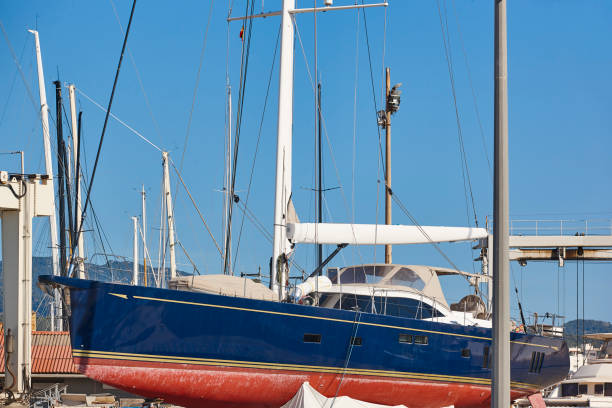 voilier sur un chantier naval en plein air. industrie de la maintenance nautique. réparer - dry dock harbor cruise ship pier photos et images de collection