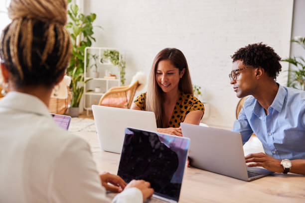 istock Diverse young businesspeople working on laptops in a modern office 1340446918