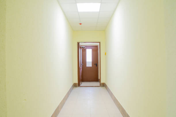 istock A doorway in a light pastel yellow corridor. New, empty building. 1340447103