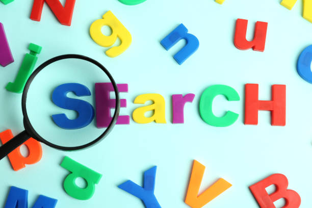 istock Magnifying glass over word SEARCH made with magnet letters on light blue background, flat lay 1340447228