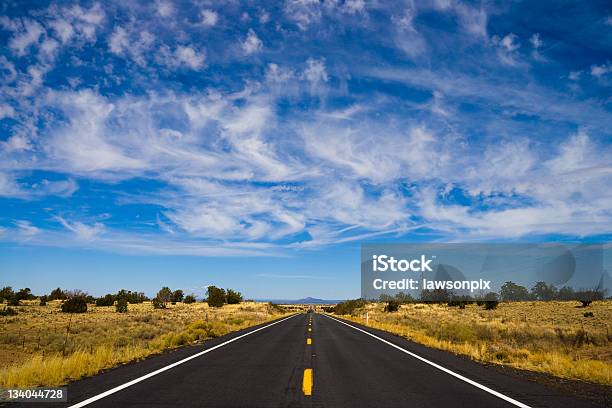 Long Straight Road Under Wispy Clouds Stock Photo - Download Image Now - Acute Angle, Blue, Road