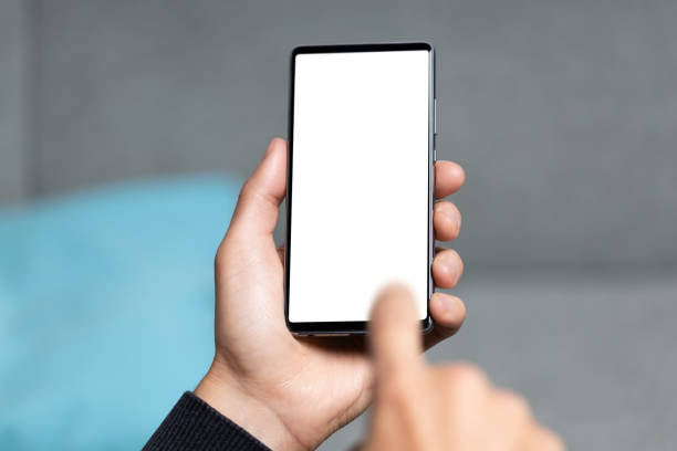 istock Hand holding smart phone and finger touching it 1340448569