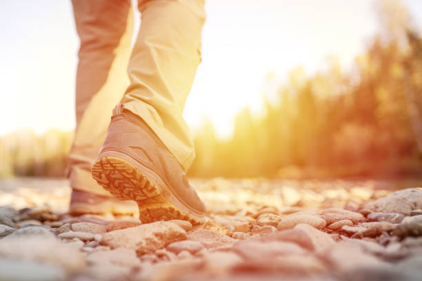 one person walking outdoors on pebble shore of river
