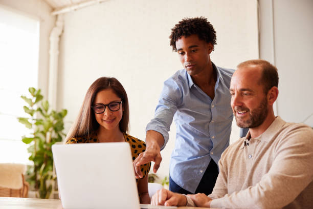 istock Diverse businesspeople working on a laptop at an office desk 1340452473