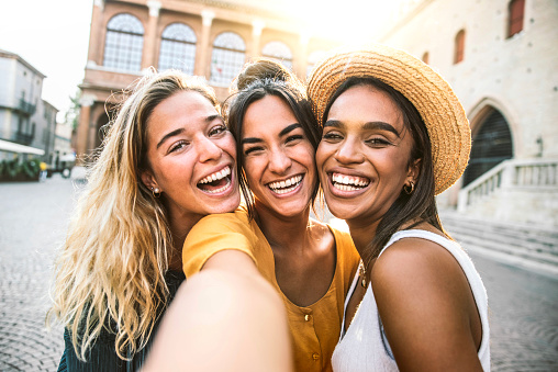 Three young women taking selfie portrait on city street - Multicultural female friends having fun on vacation hanging outdoor - Friendship and happy lifestyle concept