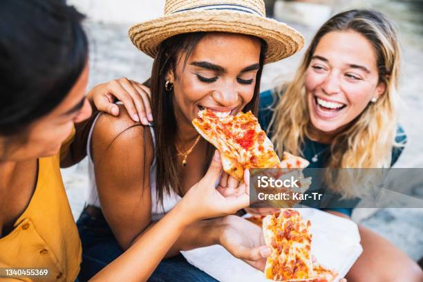 Three Young Female Friends Sitting Outdoor And Eating Pizza Happy Women Having Fun Enjoying A Day Out On City Street Happy Lifestyle Concept Stock Photo - Download Image Now