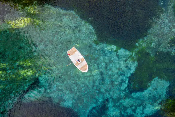 Photo of Aerial view of woman rowing boats on the blue spring water.Gökpınar lake.