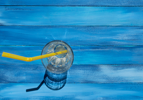 Empty glass with drinking straw on wooden table