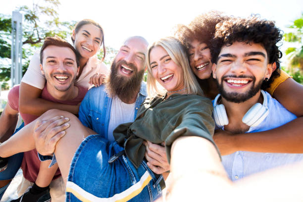 istock Multicultural happy friends having fun taking group selfie portrait outside - Mixed race young people laughing together enjoying a day out on vacation - Happy lifestyle concept. 1340458785