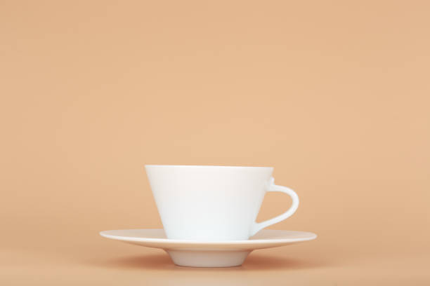 istock White ceramic coffee cup with saucer against pastel beige background with copy space 1340458968