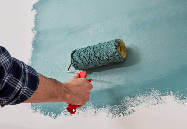istock Male hand painting wall with paint roller 1340466009