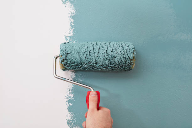close-up of a paint roller on the wall - painting imagens e fotografias de stock