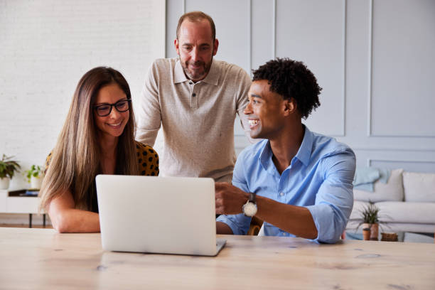 istock Diverse businesspeople working on a laptop together in a modern office 1340468068