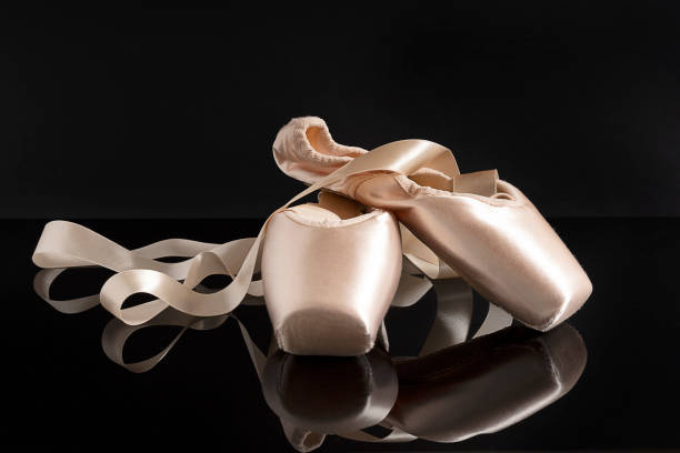 New pink ballet pointe shoes on black background