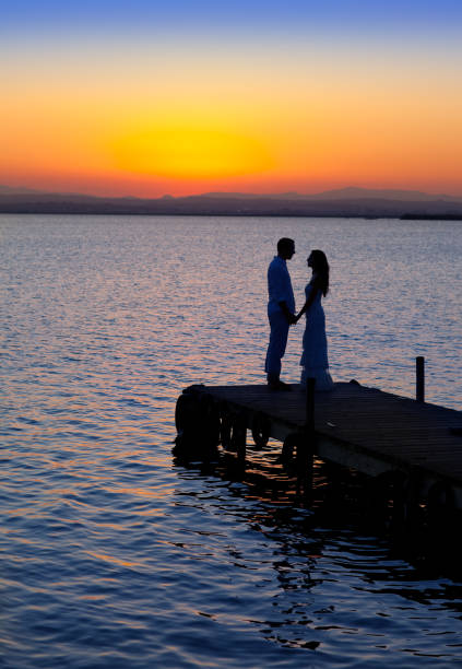 istock couple in love back light silhouette at lake 1340469792