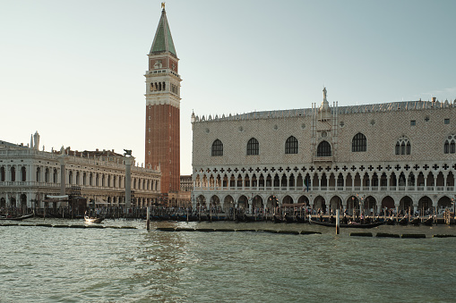 Venice, Italy - March 4, 2023: The embankment with palaces and gondolas at sunny morning.