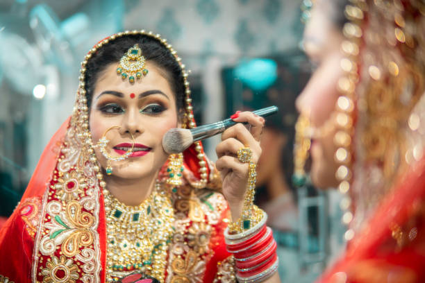 istock Beautiful traditional Indian bride getting ready for her wedding day  the makeup front of a mirror. 1340470362