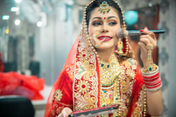 istock Beautiful traditional Indian bride getting ready for her wedding day  the makeup front of a mirror. 1340470367