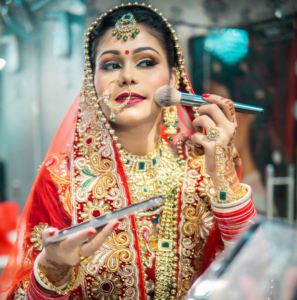 istock Beautiful traditional Indian bride getting ready for her wedding day  the makeup front of a mirror. 1340470369