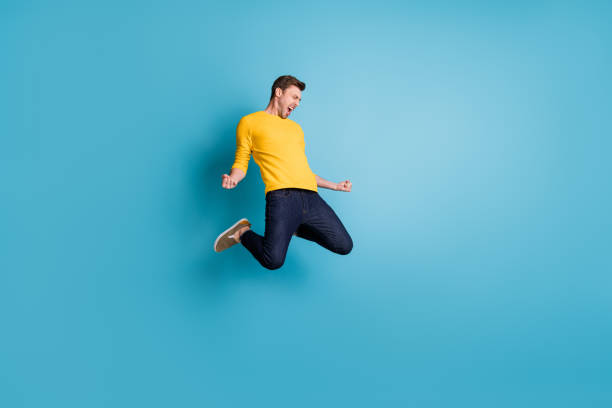 istock Full length body size view of nice cool crazy cheerful guy jumping having fun celebrating isolated over bright blue color background 1340471987