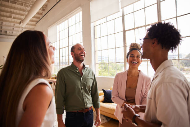 istock Group of diverse businesspeople laughing together while standing in an office 1340472003