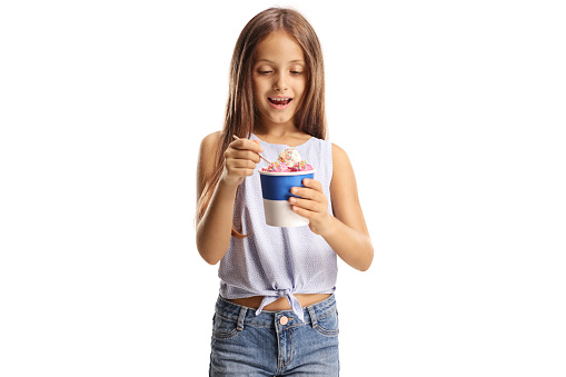 Excited cute girl holding ice cream in a paper cup isolated on white background