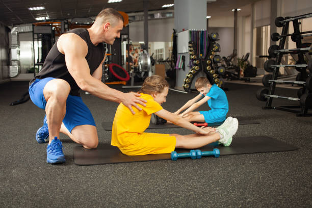 istock coach helps children perform physical exercises in gym 1340472465