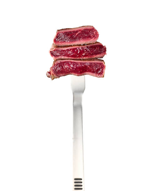 istock fried ribeye pieces strung on a large metal fork and isolated on a white background 1340472554