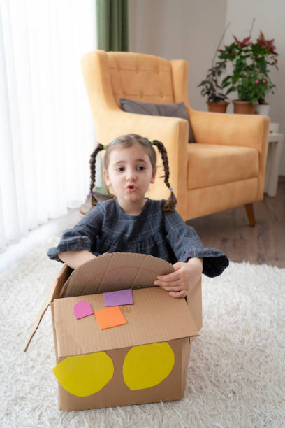istock Little girl having fun with cardboard box 1340475011