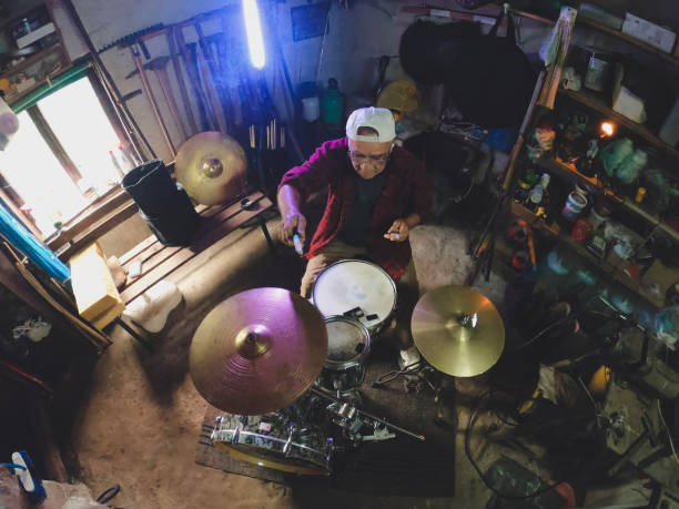 istock An older man practices playing drums in his garage 1340475267
