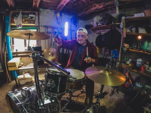 istock An older man practices playing drums in his garage 1340475273