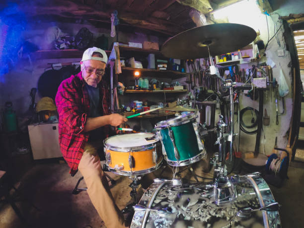 istock An older man practices playing drums in his garage 1340475276