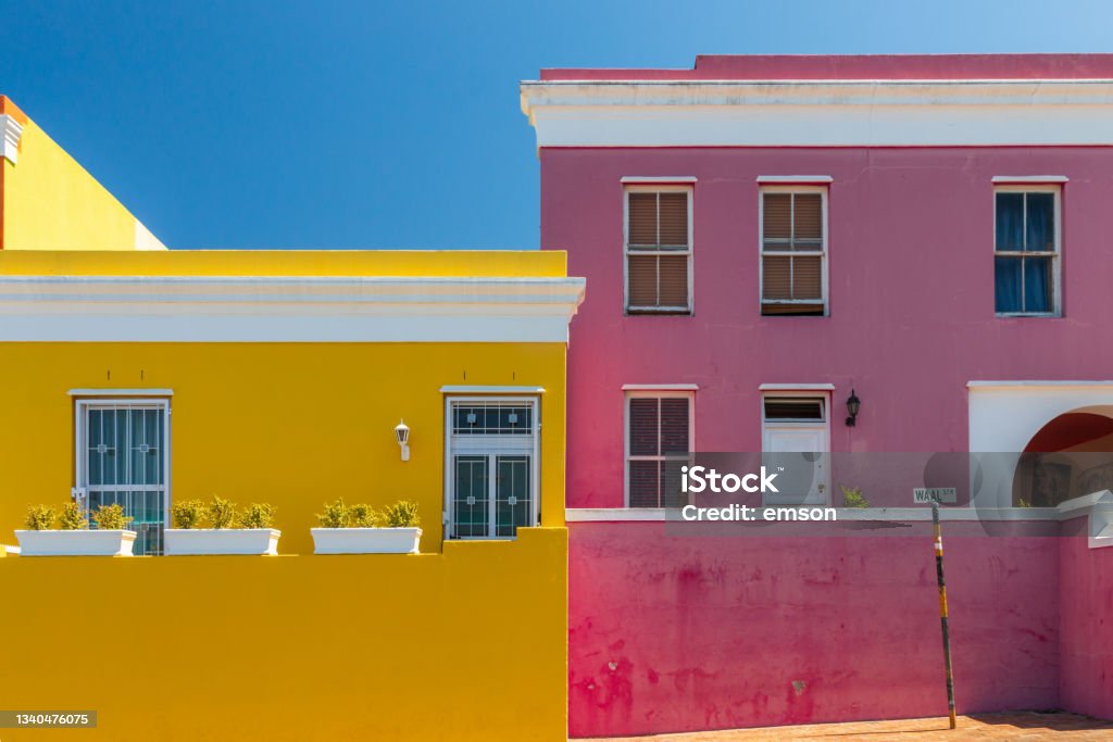 Colorful facades of old houses in yellow and pink, Bo Kaap Malay Quarter, Cape Town, South Africa Colorful facades of old houses in yellow and pink, Bo Kaap Malay Quarter, Cape Town, South Africa against blue sky Africa Stock Photo