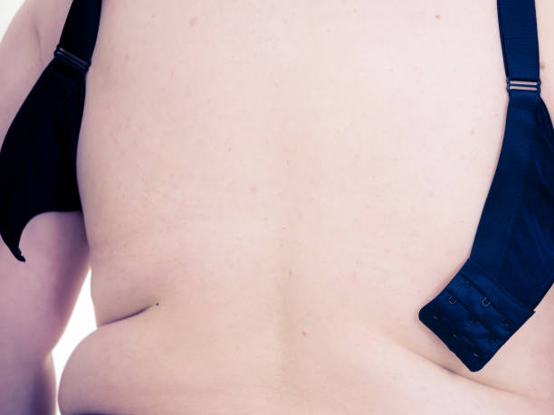 istock Woman back view putting on her bra lingerie. 1340477698