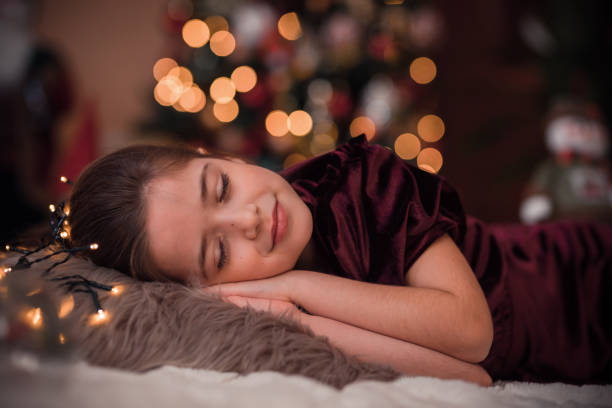 mignonne jeune fille dormant la veille de noël - new years day new years eve new year ethnic photos et images de collection