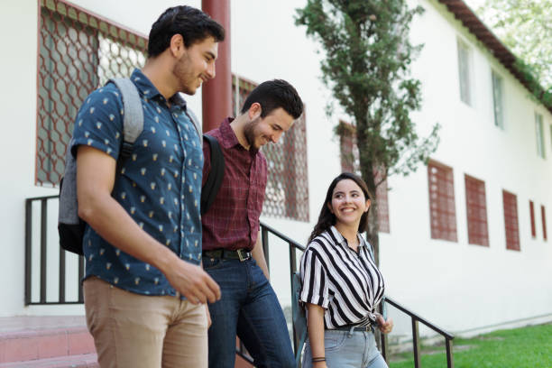 istock Latin students going down stairs of building and smiling 1340480575
