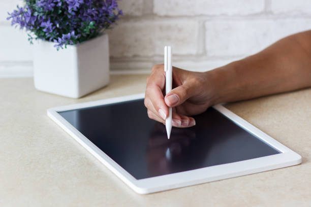 istock Woman drawing with a tablet device, blurred background 1340480924
