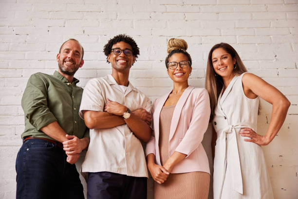 istock Diverse businesspeople smiling while standing against a wall in an office 1340481885