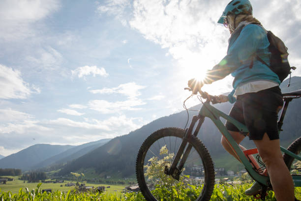 istock Female mountain biker relaxes in grassy meadow 1340490077
