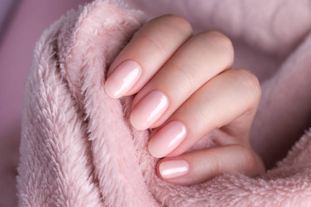 istock Hand in sweater with nude nails on pink textile background 1340490788