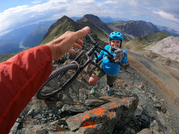 pov della mountain bike femminile che cammina su per la montagna - exploration mountain teamwork mountain peak foto e immagini stock