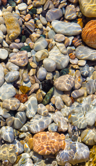 Sunlight on colorful underwater pebbles at the beach