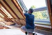 istock Craftsman caulking a new window in the attic. 1340498346