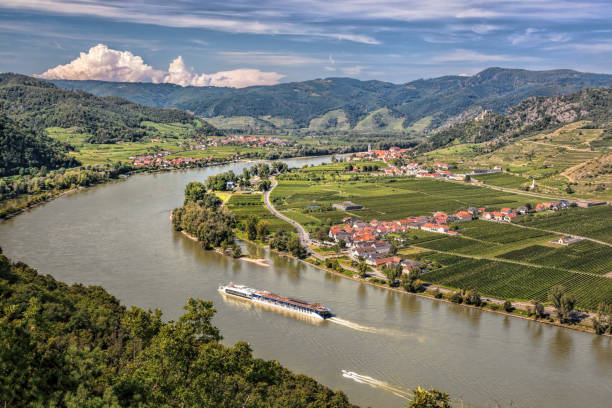 panorama de la vallée de la wachau (site du patrimoine mondial de l’unesco) avec un bateau sur le danube contre le village de duernstein en basse-autriche, autriche - danube valley danube river vineyard austria photos et images de collection