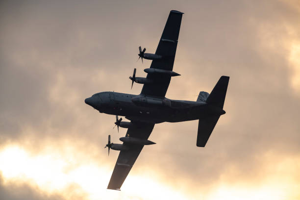 Lockheed C-130 Hercules of the Royal Dutch Air Force flying in mid air during sunset near Deelen airflield at the Veluwezoom nature reserve in Gelderland, The Netherlands.