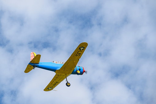 Vintage propellor airplane Vultee BT-13A Valiant flying in the sky. The Vultee BT-13 was used as a basic training aircraft for American pilots before and during World War II.