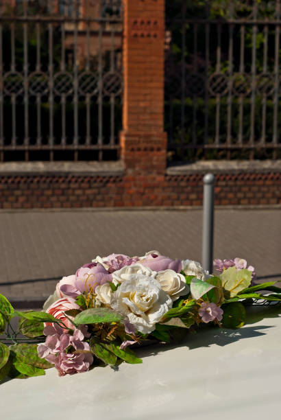istock White wedding flowers attached to a gray car. Wedding floristics and decorations close up. Wedding and holiday concept. 1340507521